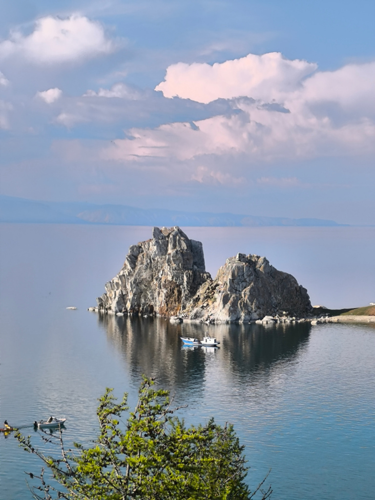 Скала Шаманка на мысе Бурхан на Байкале летом, рядом кораблик на воде. Скала Шаманка на мысе Бурхан на Байкале летом, рядом кораблик на воде.